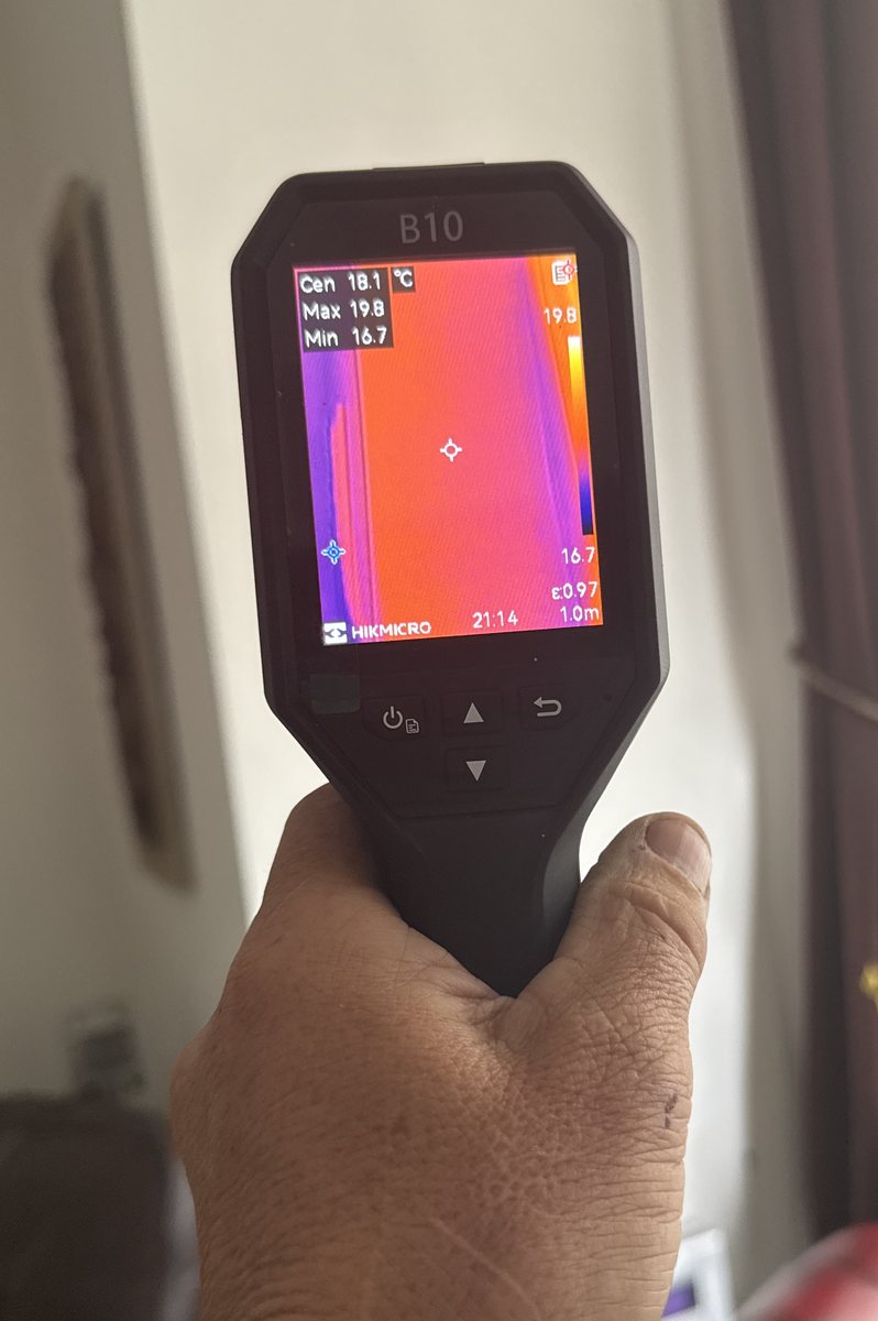 Thermal imaging camera showing a cold vertical band on a wall during a damp survey